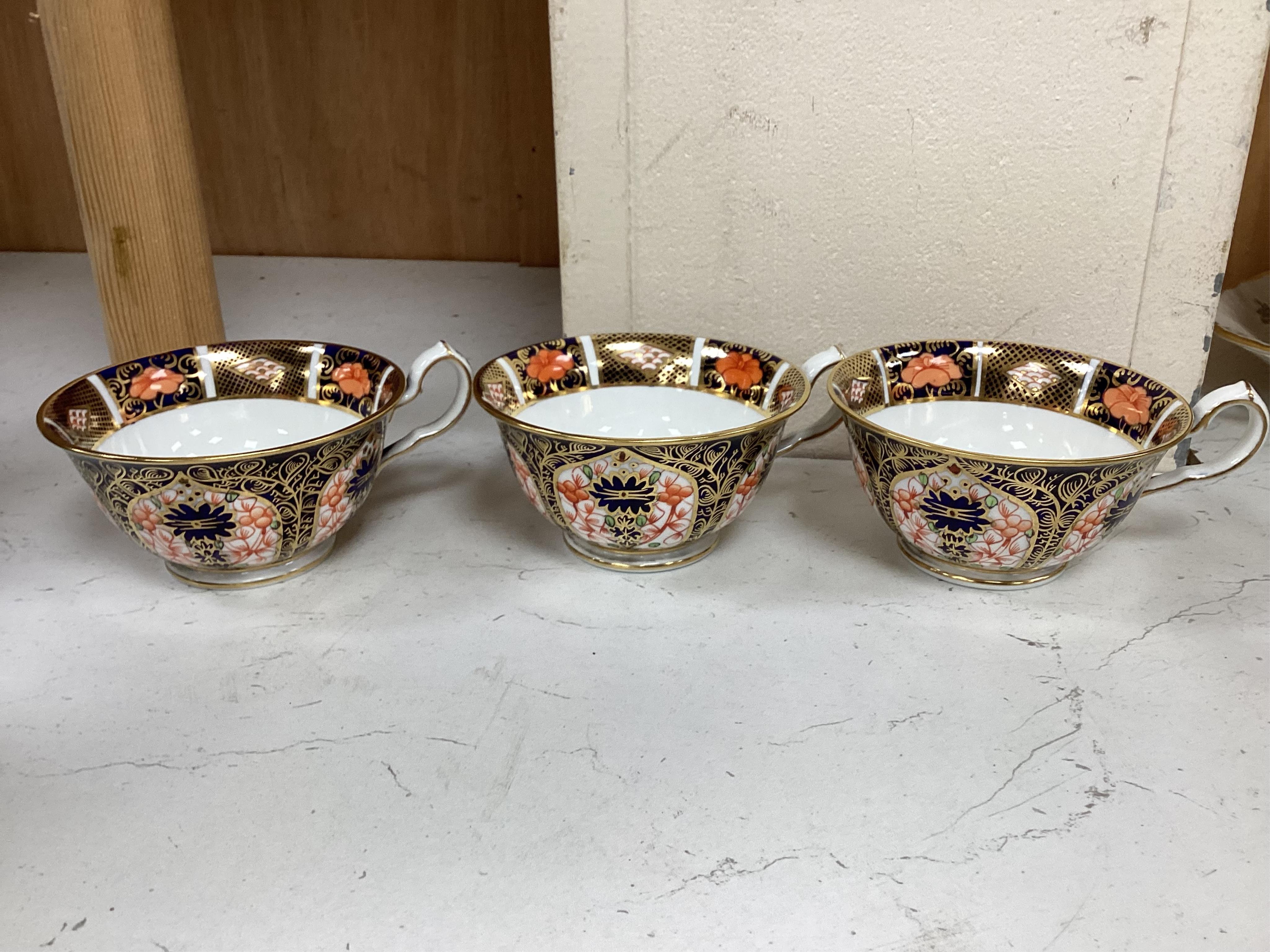A quantity of Royal Crown Derby Imari to include a sandwich plate, cups and saucers and and miniature twin handled cups, largest 27cm in diameter